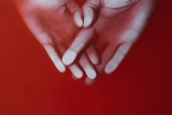 Αντρικά και γυναικεία χέρια πιεσμένα στο γυαλί σε κόκκινο νερό, η έννοια της αγάπης και του πόνου — Φωτογραφία Αρχείου