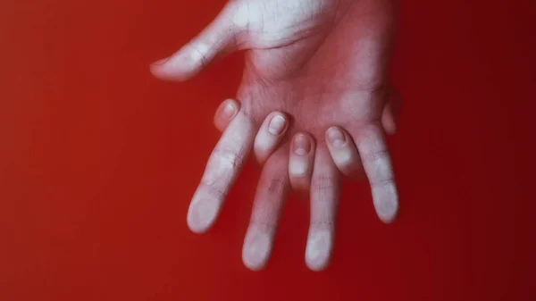 Mano femenina agarra la palma de un hombre entre los dedos en agua roja, el concepto amor fuerza, cubierta para el arte en el género de terror — Foto de Stock