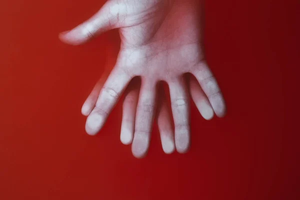 Palma femenina y masculina con los dedos extendidos al lado ahogado en agua roja, concepto de amor misterioso y relaciones — Foto de Stock