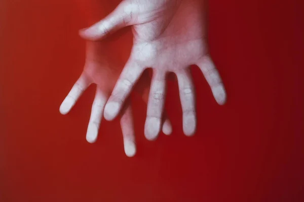 Palma femenina y masculina con los dedos extendidos al lado ahogado en agua roja, concepto de amor misterioso y relaciones — Foto de Stock