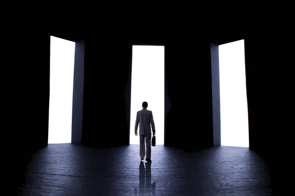 Silhouette of a young man in a business suit with a briefcase in front of three open doors, person decides what path to choose, the concept of life choices and business — Stock Photo, Image