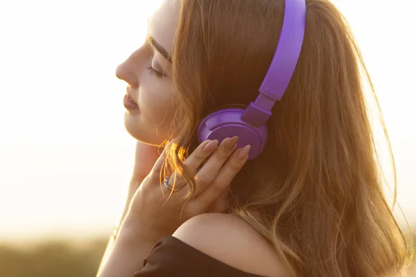 Tiener meisje in koptelefoon luisteren naar muziek op de natuur, jonge vrouw is ontspannen in de zomer veld — Stockfoto