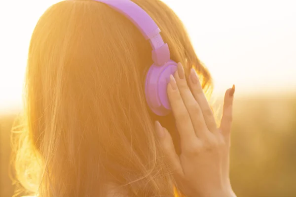 Κορίτσι στα ακουστικά ακούγοντας μουσική για τη φύση στο ηλιοβασίλεμα στο πεδίο — Φωτογραφία Αρχείου