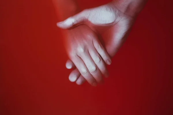 Сплетение рук мужчины и женщины в кровавой красной воде, концептуальная драма в отношениях и предательство — стоковое фото