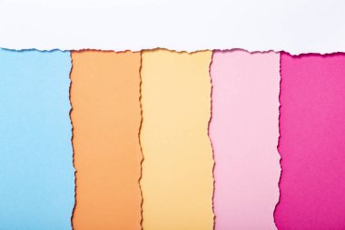 dikey olarak yatan yırtılmış karton çok renkli şeritler soyut arka plan, üst görünüm