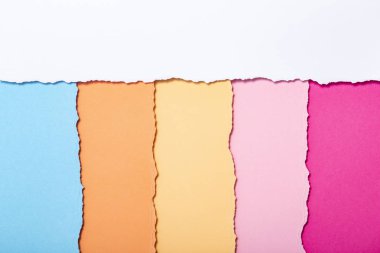 dikey olarak yatan yırtılmış karton çok renkli şeritler soyut arka plan, üst görünüm