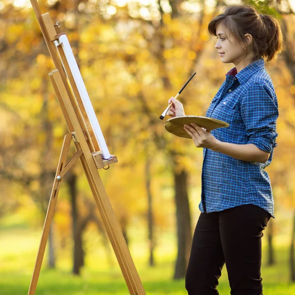 Genç bir kadın tuvale resim çiziyor, ressam kız dinleniyor, yaşam tarzı kavramı ve bir hobi. — Stok fotoğraf