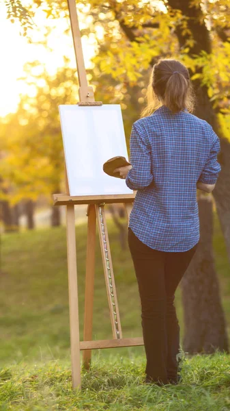 Genç kadın ressam tuval üzerine resim çiziyor. — Stok fotoğraf