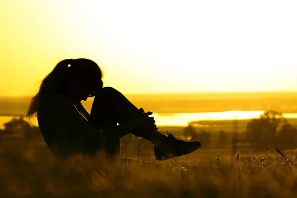 Silhouette di una donna che fa esercizi fisici in natura al tramonto, sport femminile sul campo, concetto di sport e ricreazione — Foto Stock