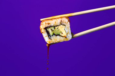 renkli bir arka plan üzerinde çubukları arasında lezzetli rulo, suşi damlaso sosu damlaları, gıda arka plan, Japon mutfağı