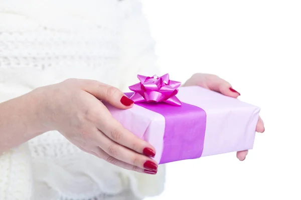 Girl holding a present in hands, woman with gift box wrapped in decorative paper on white isolated background, concept winter holiday Stock Image