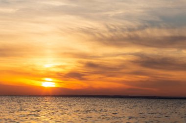 denizde gün batımı arka plan, kuşlar güneş ışınları tarafından aydınlatılan bulutlar arasında sinek