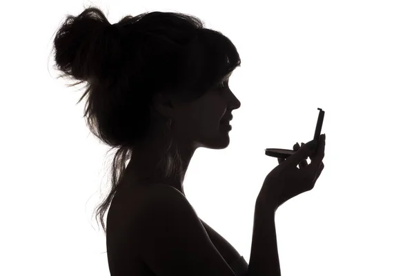 Silhouette of woman admiring herself in a mirror, profile of a woman face, concept of fashion and beauty — Stock Photo, Image