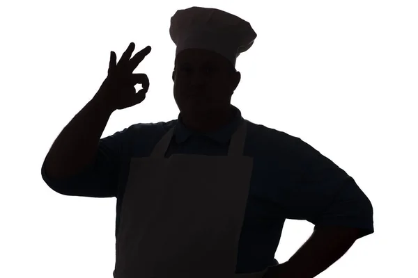 Silhouette of a happy chef on a white isolated background, male hand shows ok — Stock Photo, Image