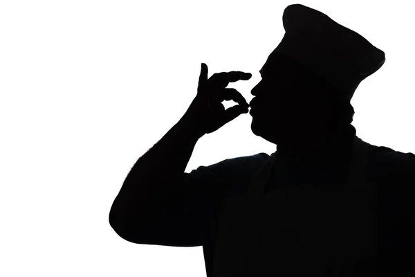 Silhouette eines glücklichen Kochs, der Finger aus köstlichen Gerichten küsst, das Profil einer Person in einer Küchenuniform, die mit der Hand ok zeigt — Stockfoto