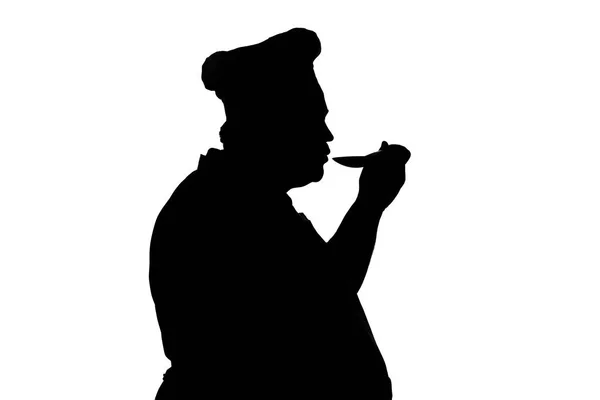 Silhouet illustratie van een Chief-fornuis met lepel, fornuis proeverij schotel op een witte geïsoleerde achtergrond, Profiel van een man in hoed en schort, Food Industry concept — Stockfoto