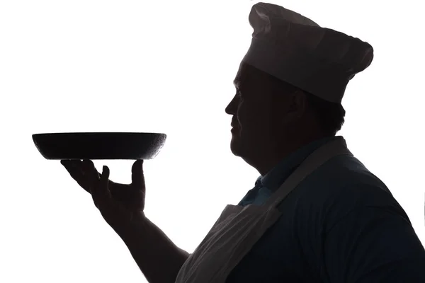 Silhueta de um chef carregando um prato na panela em sua mão sobre um fundo isolado branco — Fotografia de Stock