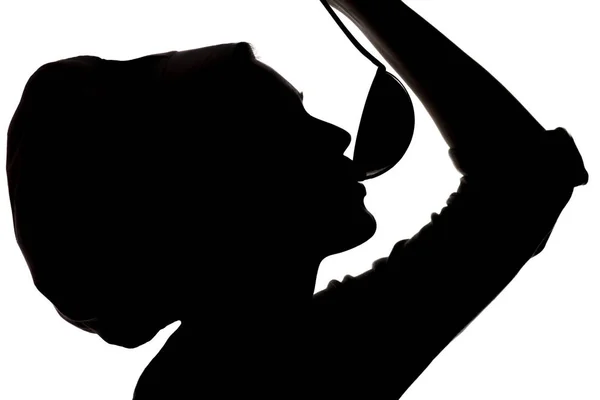 Silhouet van de vrouw koken in een pet, Profiel van een meisje proeverij de soep uit een pollepel over een geïsoleerde witte achtergrond — Stockfoto