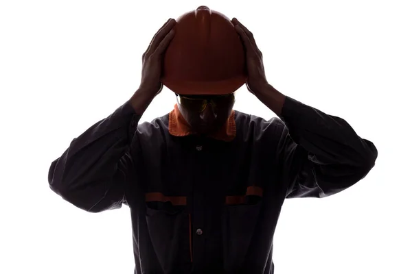 두통과 소음으로 고통받는 건설 노동자의 실루엣, 흰색 고립 된 배경에 헬멧을 쓴 남자 — 스톡 사진