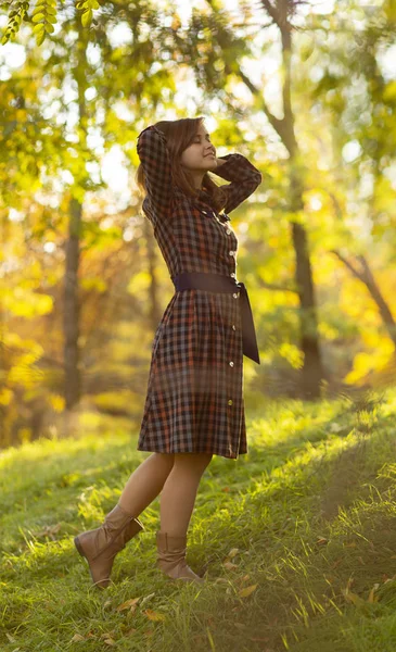 秋に自然の中を歩くドレスを着た美少女の肖像画、草と丘の上に立って太陽の光を楽しむ若い女性 — ストック写真