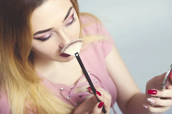 Retrato de una hermosa joven con cepillo de maquillaje en un estudio, cara de mujer, cosméticos y concepto de belleza natural —  Fotos de Stock