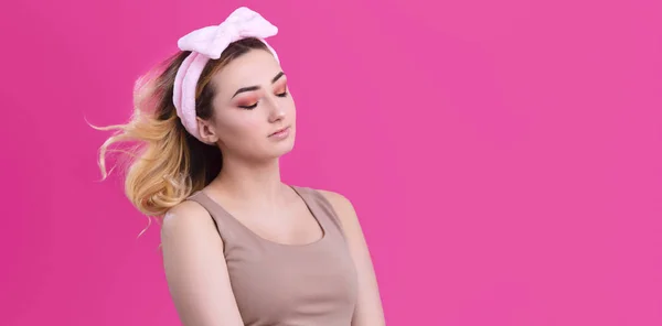 一个美丽的女孩在头带在粉红色的工作室背景，美容的概念，广告化妆品，身体护理的肖像 — 图库照片