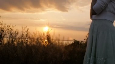 gün batımında Tanrı'ya dua genç kadın figürü siluet, kız alanında çene ellerini katlanmış, din kavramı