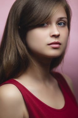 pembe renkli arka planda güzel bir genç kadının stüdyo portresi, koyu sarı saçlı bir kız, doğal güzellik kavramı, model, fotoğraf çekimi