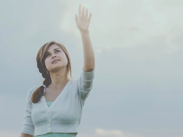 Menina bonita levantou a mão para o céu e nuvens, o conceito de pureza, beleza, religião, espiritualidade — Fotografia de Stock