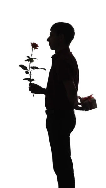 Silhouette profil d'un homme avec un coffret cadeau et une fleur de rose pour sa bien-aimée, le gars félicite sur fond blanc isolé, concept vacances, soins, amour, romance — Photo