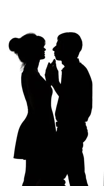 Silhouette eines jungen verliebten Mannes und einer verliebten Frau auf weißem, isoliertem Hintergrund, Mann berührt Hände einer Frau und tanzt langsam, Konzeptromantik — Stockfoto