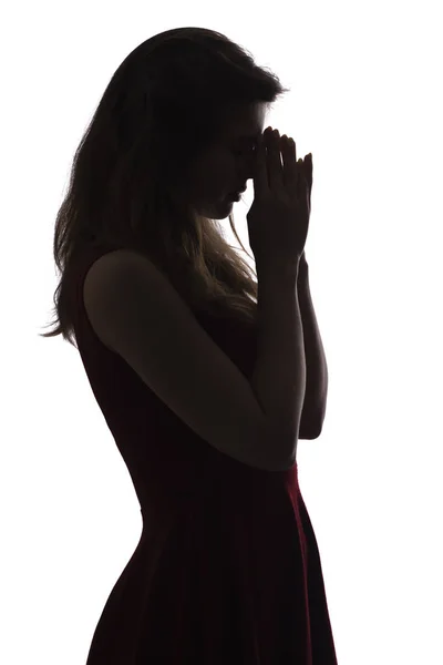 Профільний силует молодої жінки в одязі, молитва, фігура відчайдушної красивої дівчини на білому ізольованому фоні, концептуальна релігія — стокове фото