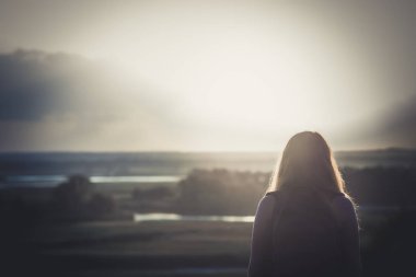 omuzlarında bir sırt çantası ile genç kız bir alanda oturan ve gün batımı zevk, yürüyüş kavramı, yürüyüş, dinlenme, aktif yaşam tarzı