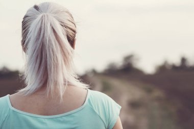 alanında koşu pistinin arka planda kadın başının arka, doğa sporları için at kuyruğu ile kız