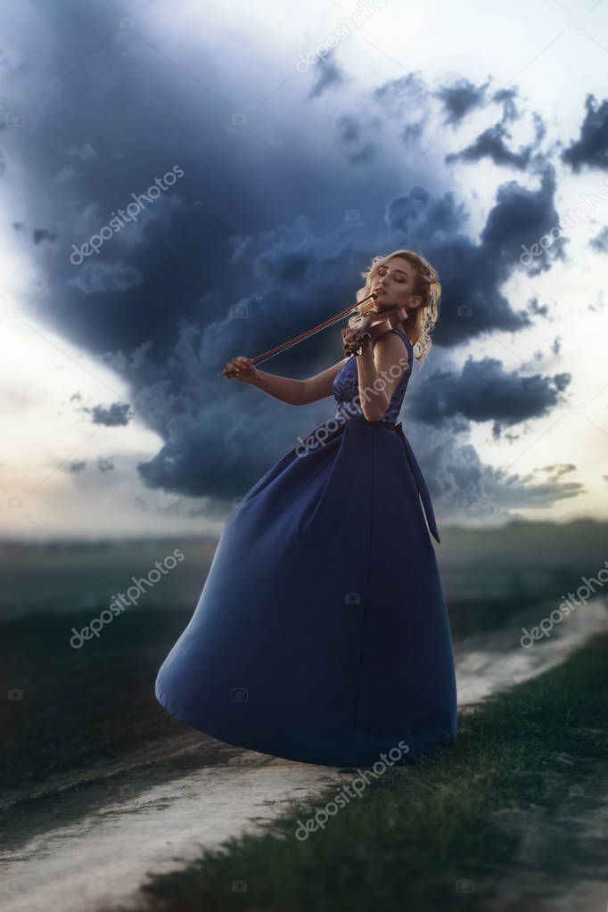 figure of young woman in long dress with violin in field at sunset, girl engaged in musical art, performance on nature, concept passion in music