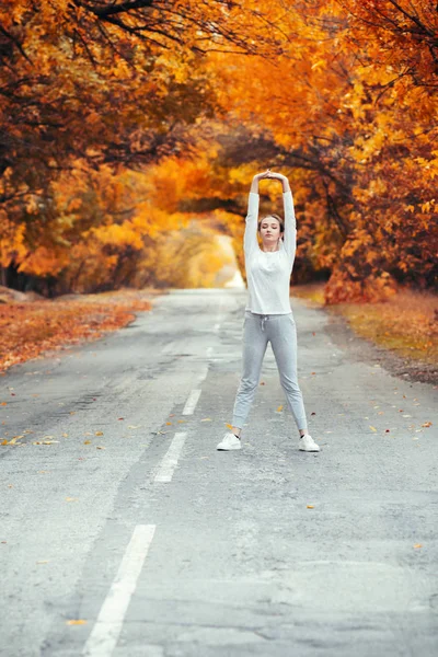 Szczupła Młoda Kobieta Ćwiczeniach Odzieży Sportowej Wyciąga Ręce Góry Stojąc — Zdjęcie stockowe