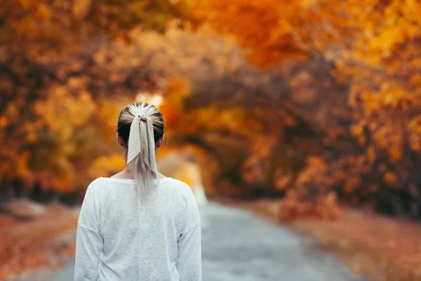 若い女の子が立ち上がって走り出す準備ができていた秋の紅葉を背景に健康的なライフスタイルとボディケアをコンセプトに — ストック写真