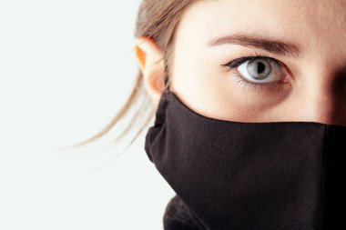 2020 'de karantina ve salgın altında siyah bir maske takan üzgün genç bir kadının yüzü.,