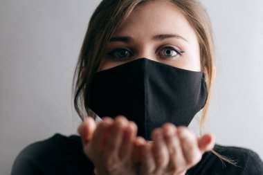 Koruyucu siyah maskeli güzel bir kadının portresi hava öpücüğü, karantina sınırlamaları ve salgın hastalık gönderiyor.