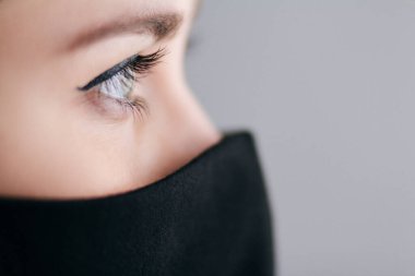 2020 'de karantina ve salgın, bilim ve gelecek kavramları altında siyah stil maskeli, moda ve yaşam tarzı olan güzel bir kadının yüzünün bir parçası.