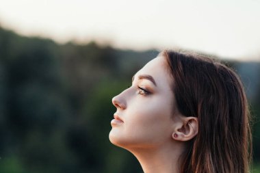 Ufukta kadın kafası, yüz hatları, doğada genç bir kadın, özgürlük.