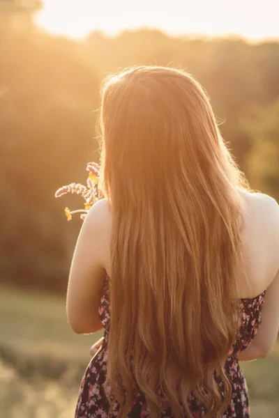 草原に野の花の花束を持つロマンチックな女の子 自然の上を歩くドレスで長い髪の若い女性 村の夏の柔らかい写真 — ストック写真