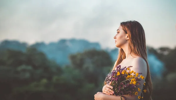 草原に野の花の花束を持つ美しい女の子 自然の上を歩くドレスで長い髪の若い女性 村の夏の柔らかい写真 — ストック写真