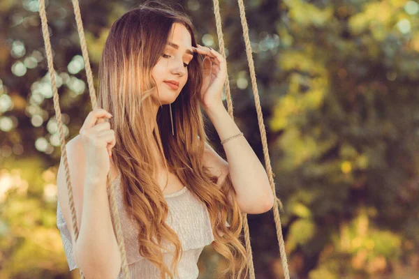夏の大自然の中でロープスイングで揺れる長い髪を持つ美しい女の子 若い女性は日没でリラックス レジャー活動 ライフスタイルコンセプト — ストック写真