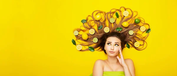 Menina Bonita Deitada Fundo Amarelo Brilhante Com Frutas Cítricas Cabelo — Fotografia de Stock