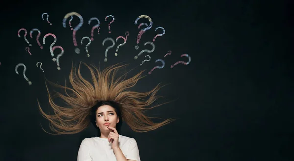 young woman lies with hair up thinking with question mark written and chalk shaded on school blackboard above head, thought process, brainstorming concept, girl finding answer top view