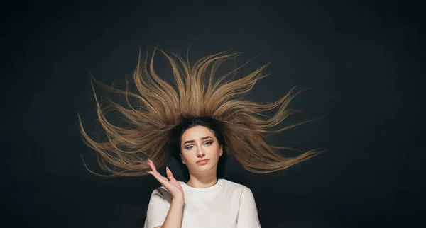 young confused woman with long hair, student on black studio background of black school board top view