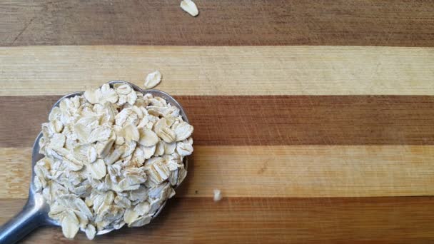 大金属勺上的大力神谷物放在厨房的木板上 上面倒着一勺谷物 素食健康食品 一个复制文本的地方 — 图库视频影像