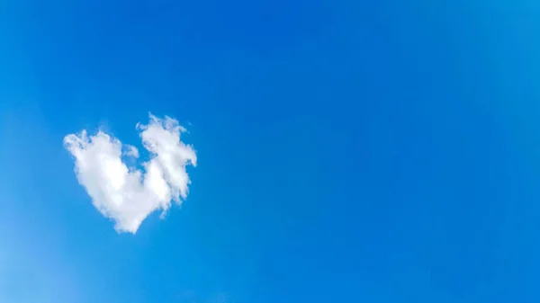 big heart-shaped clouds, beautiful background for love themes, clearly see the line of white clouds and blue sky above the sun, copy space for text