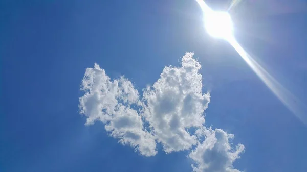 big heart-shaped clouds, beautiful background for love themes, clearly see the line of white clouds and blue sky above the sun
